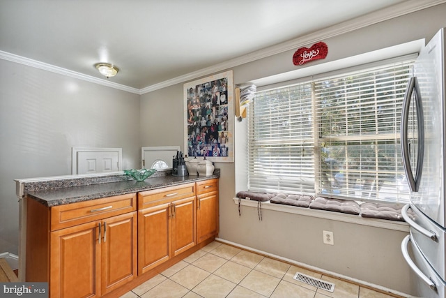 kitchen featuring light tile patterned flooring, kitchen peninsula, crown molding, and stainless steel refrigerator