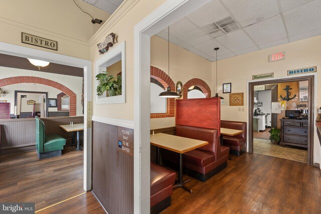 corridor with a drop ceiling and dark hardwood / wood-style floors