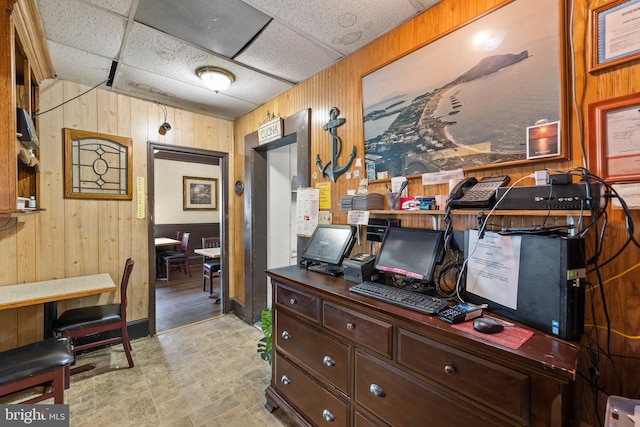 tiled home office with wooden walls and a paneled ceiling