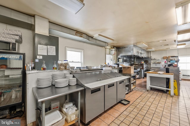 kitchen with refrigerator, a healthy amount of sunlight, wine cooler, and light tile floors