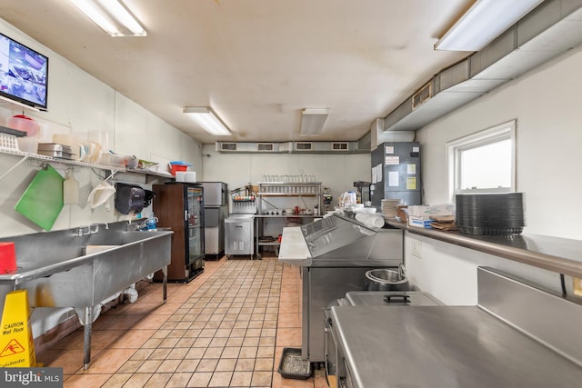 interior space with stainless steel fridge and light tile floors