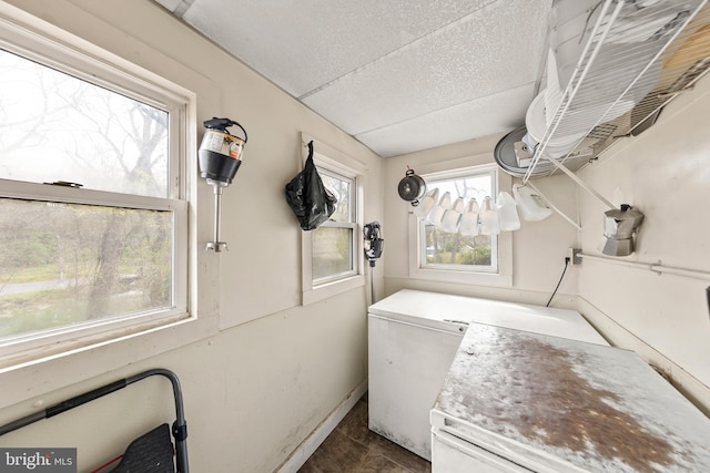 laundry area with dark tile flooring