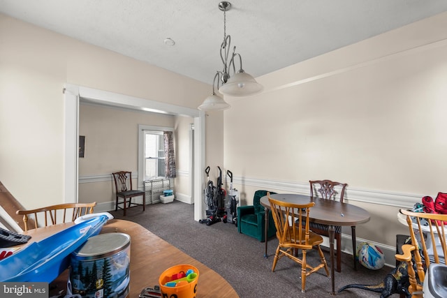 recreation room featuring dark colored carpet and a textured ceiling