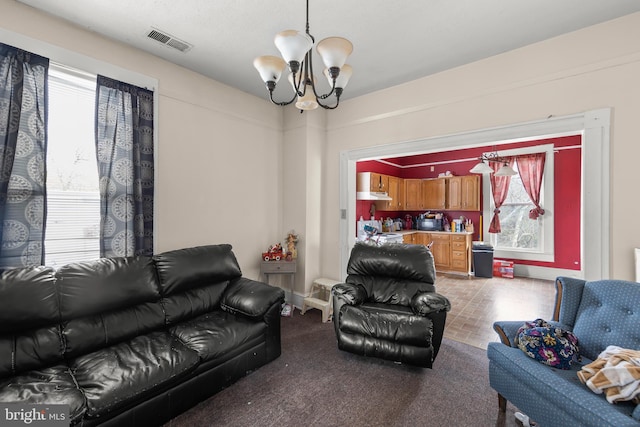 carpeted living room with a chandelier