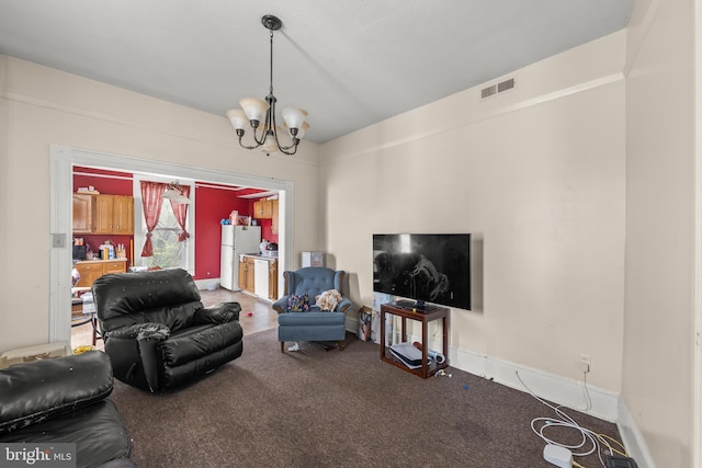 carpeted living room featuring vaulted ceiling and an inviting chandelier