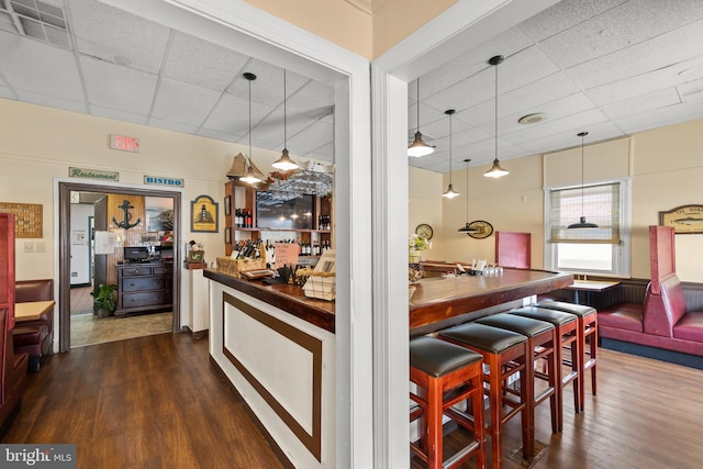 kitchen featuring dark hardwood / wood-style flooring, a paneled ceiling, pendant lighting, and butcher block counters