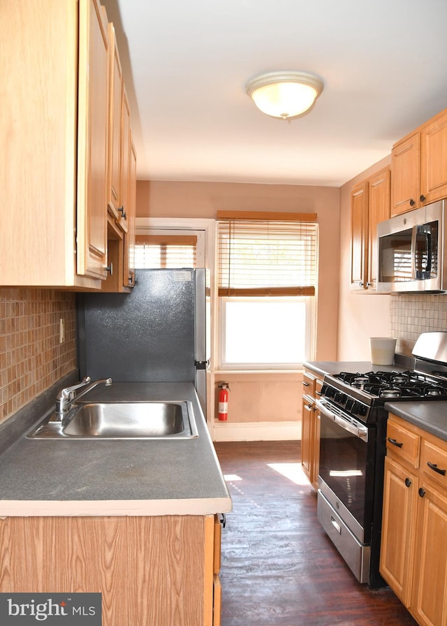 kitchen featuring light brown cabinetry, tasteful backsplash, stainless steel appliances, dark wood-type flooring, and sink