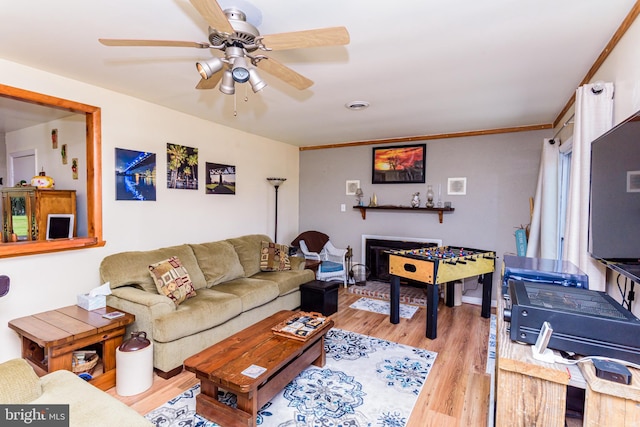 living room featuring ceiling fan, light hardwood / wood-style flooring, and ornamental molding