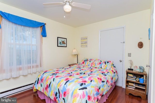 bedroom with ceiling fan, dark hardwood / wood-style flooring, and baseboard heating