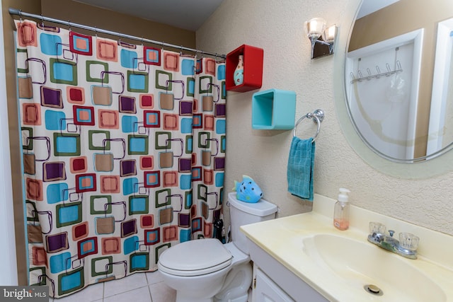 bathroom with tile patterned flooring, vanity, toilet, and walk in shower