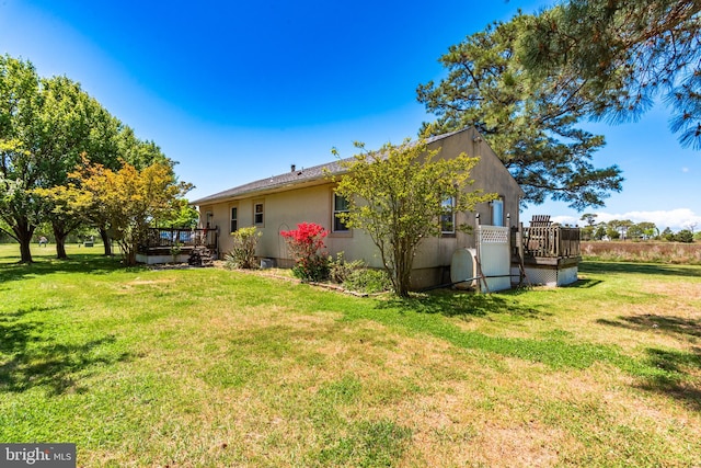 back of property with a yard and a wooden deck