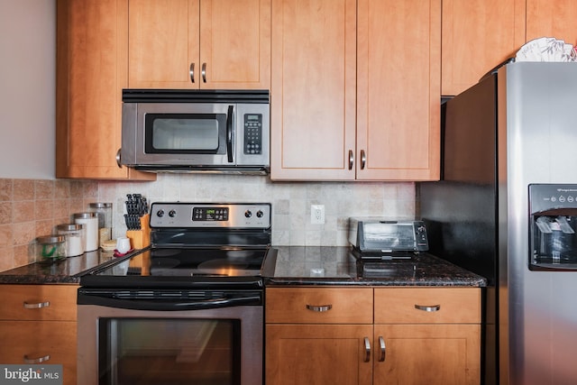 kitchen featuring dark stone counters, tasteful backsplash, and stainless steel appliances