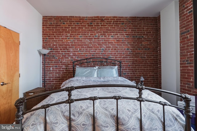 unfurnished bedroom featuring brick wall