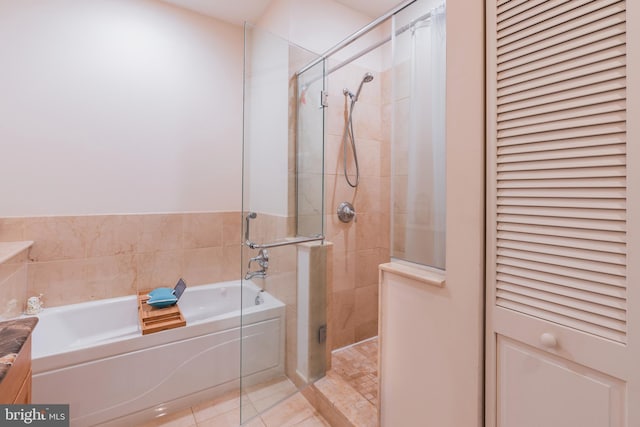 bathroom featuring plus walk in shower and tile patterned flooring