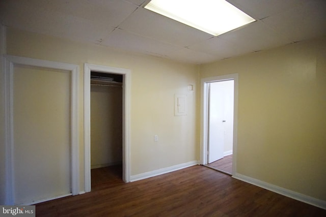 unfurnished bedroom with a closet, hardwood / wood-style flooring, and a paneled ceiling