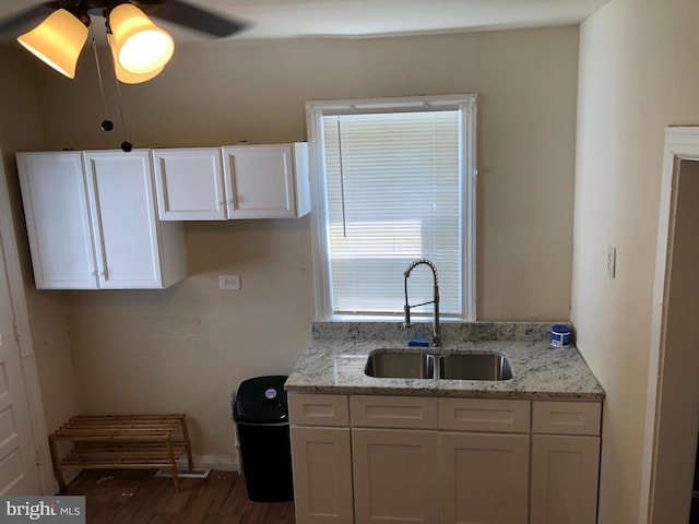 kitchen featuring wood-type flooring, sink, ceiling fan, and white cabinets