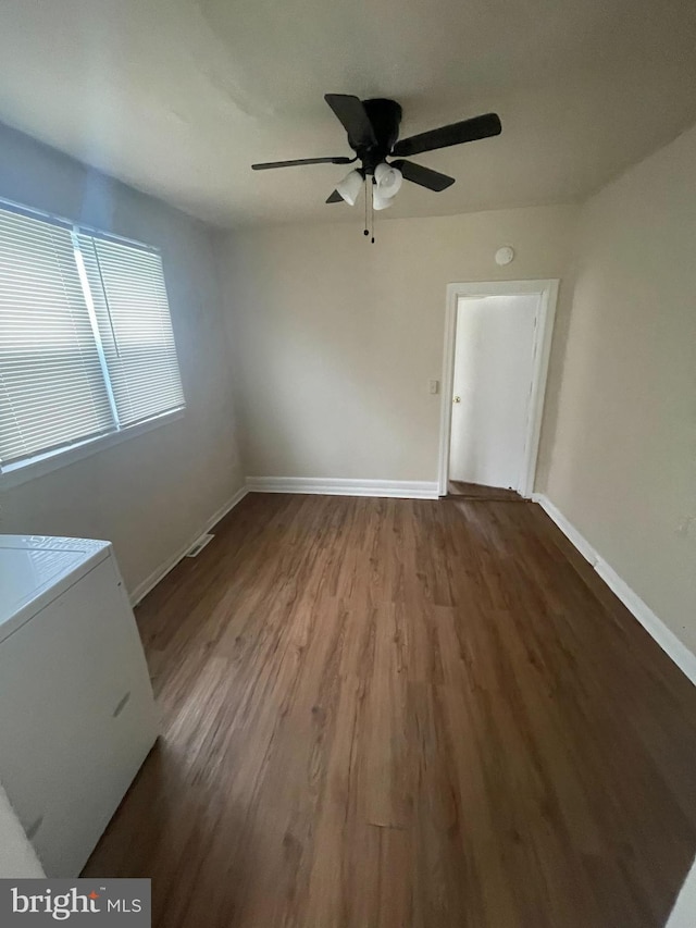 spare room with wood-type flooring, ceiling fan, and washer / dryer