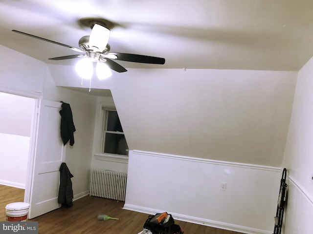 interior space with dark hardwood / wood-style flooring, ceiling fan, lofted ceiling, and radiator