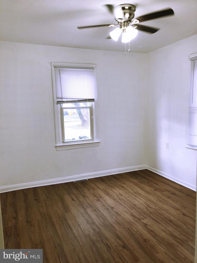 spare room with ceiling fan and dark wood-type flooring