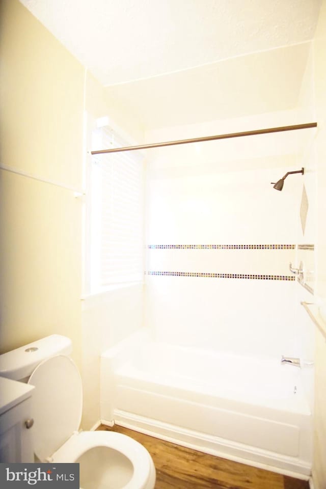 bathroom featuring shower / bath combination, hardwood / wood-style flooring, and toilet