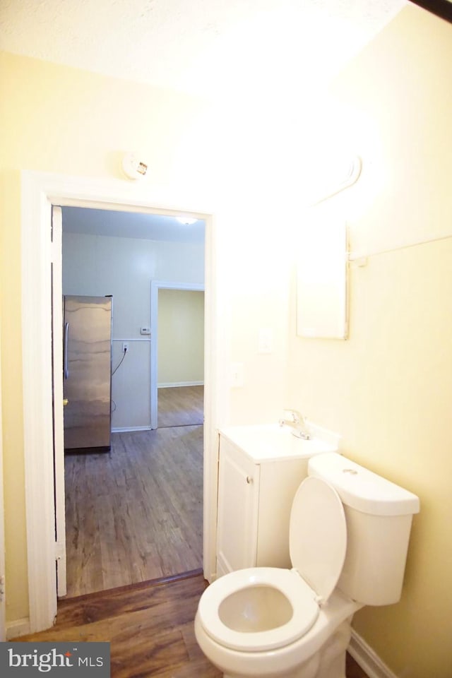 bathroom with sink, hardwood / wood-style flooring, and toilet