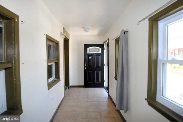 doorway featuring light tile patterned flooring and plenty of natural light