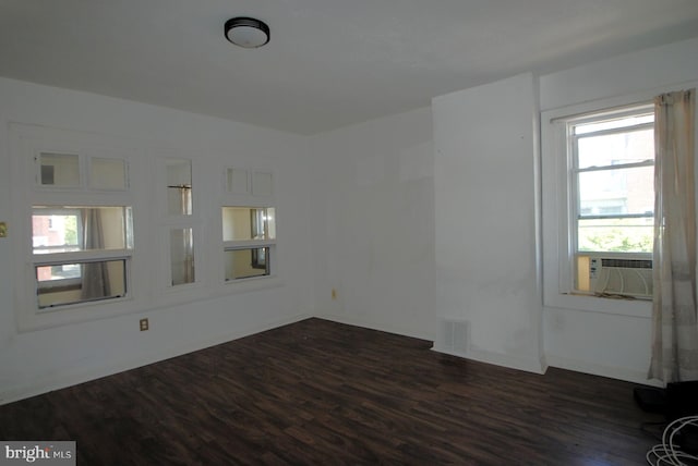 unfurnished room featuring cooling unit and dark hardwood / wood-style flooring