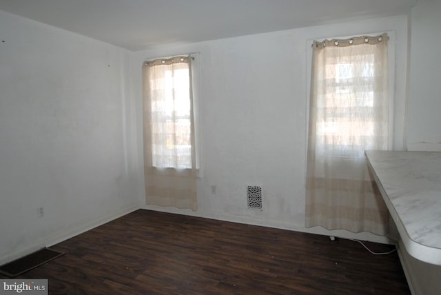 spare room featuring dark wood-type flooring