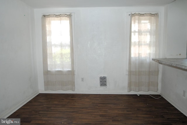 spare room with dark wood-type flooring