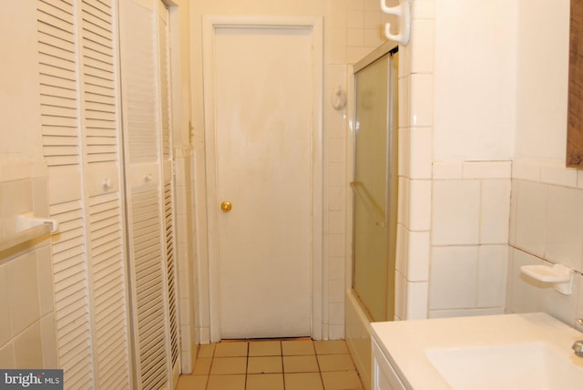 bathroom featuring tile walls, tile patterned floors, and enclosed tub / shower combo