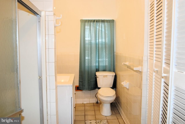 bathroom with vanity, tile walls, tile patterned flooring, and toilet