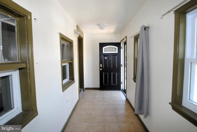 doorway to outside featuring light tile patterned flooring