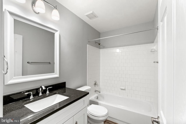 full bathroom featuring oversized vanity, tiled shower / bath combo, and toilet