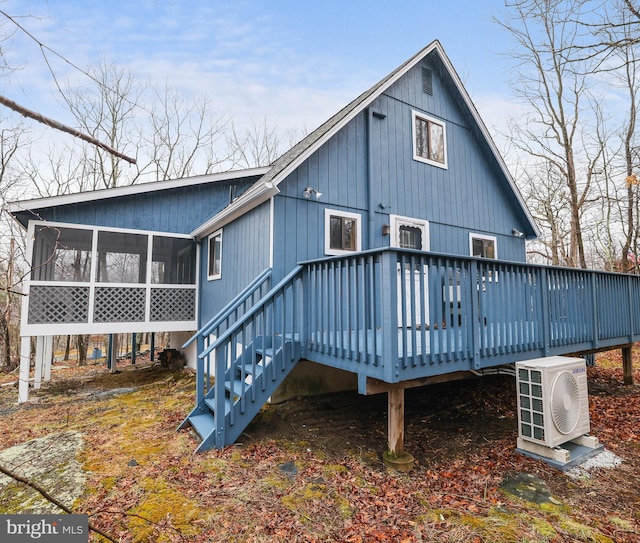 rear view of house with a deck and a sunroom