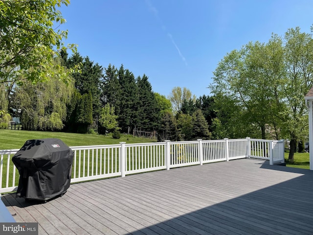 wooden terrace featuring area for grilling and a yard