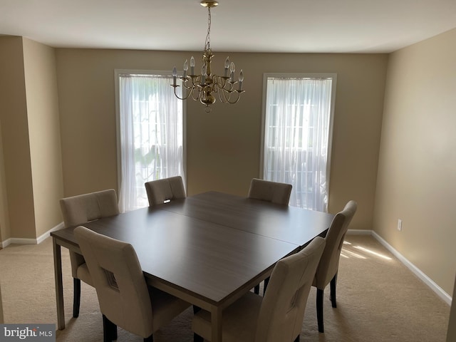 dining room featuring a chandelier and light colored carpet