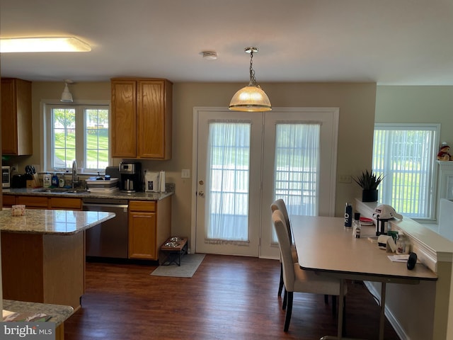 kitchen with decorative light fixtures, dark wood-type flooring, sink, light stone counters, and dishwasher