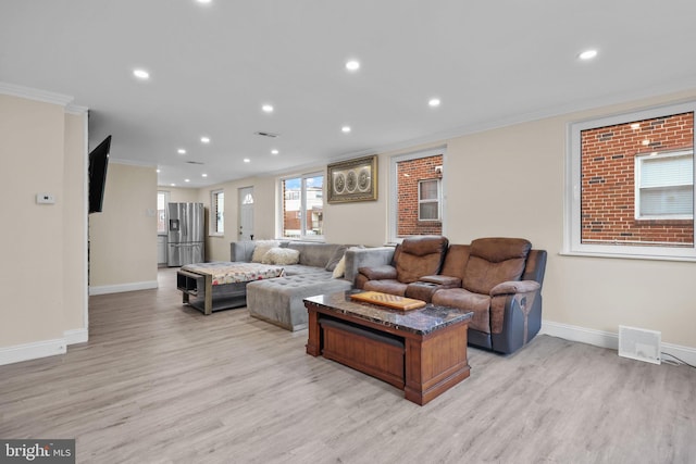 living room with ornamental molding and light wood-type flooring