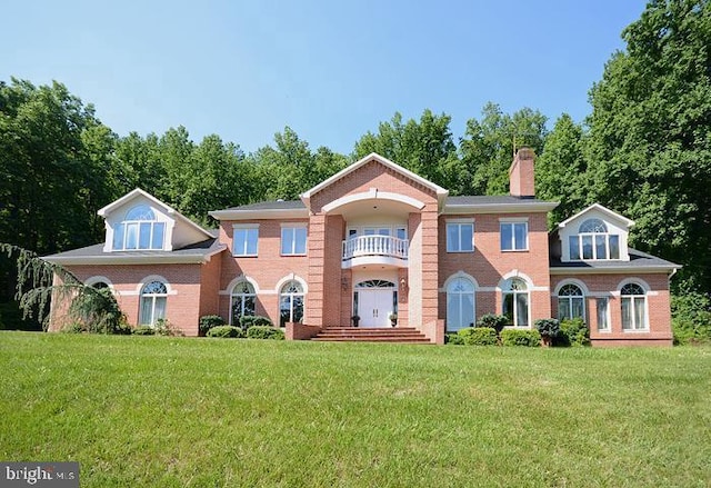 view of front of home featuring a front lawn and a balcony