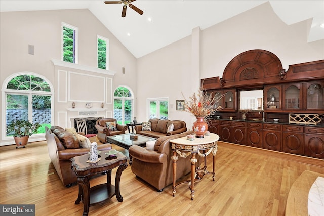 living room featuring a wealth of natural light, ceiling fan, and light wood-type flooring