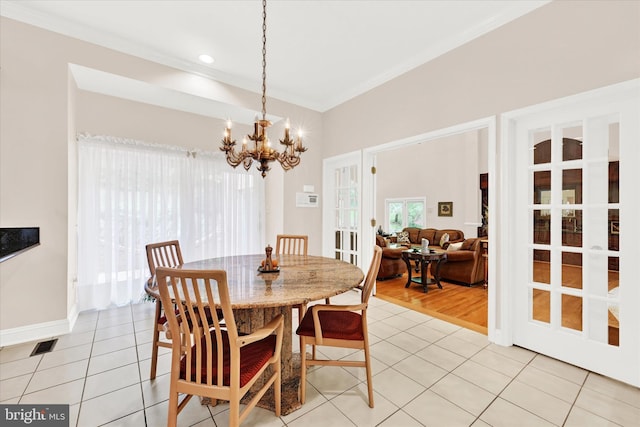 dining area featuring ornamental molding, an inviting chandelier, french doors, and light tile floors