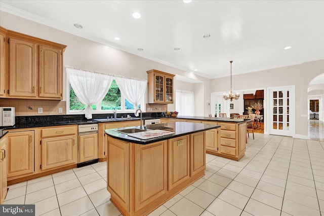 kitchen featuring tasteful backsplash, decorative light fixtures, light tile floors, and an island with sink