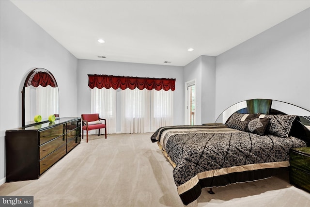 bedroom featuring light colored carpet and multiple windows