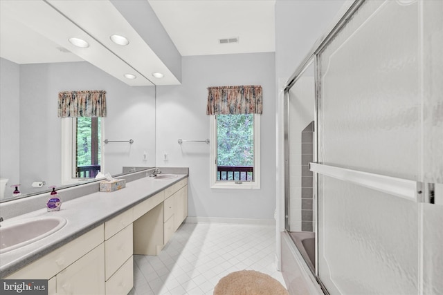 bathroom with large vanity, tile floors, double sink, and bath / shower combo with glass door