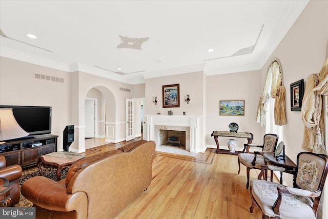 living room featuring light hardwood / wood-style flooring and ornamental molding