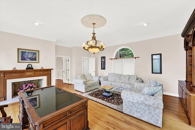 living room with ornamental molding, light hardwood / wood-style flooring, and an inviting chandelier