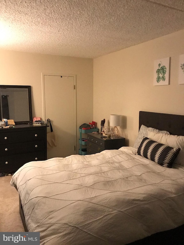 carpeted bedroom featuring a textured ceiling