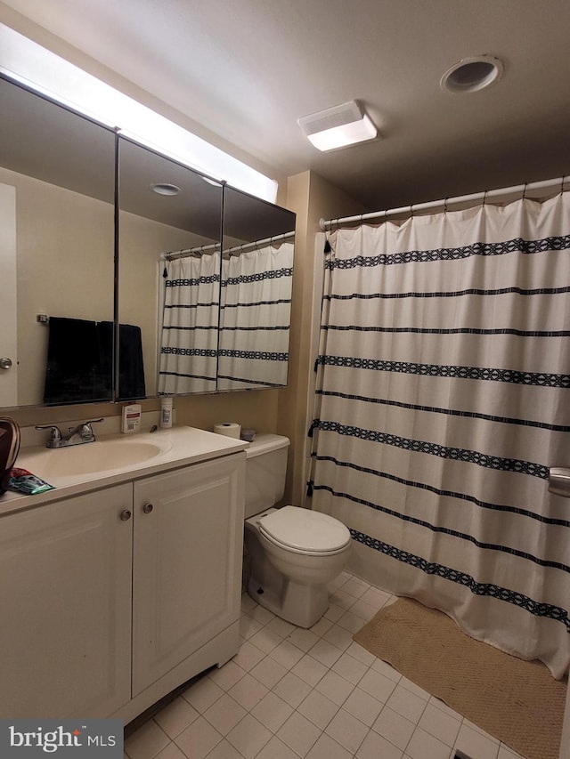 bathroom with toilet, tile flooring, and large vanity