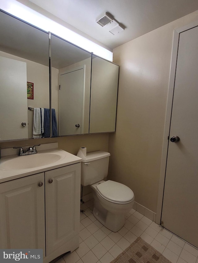 bathroom with oversized vanity, tile floors, and toilet