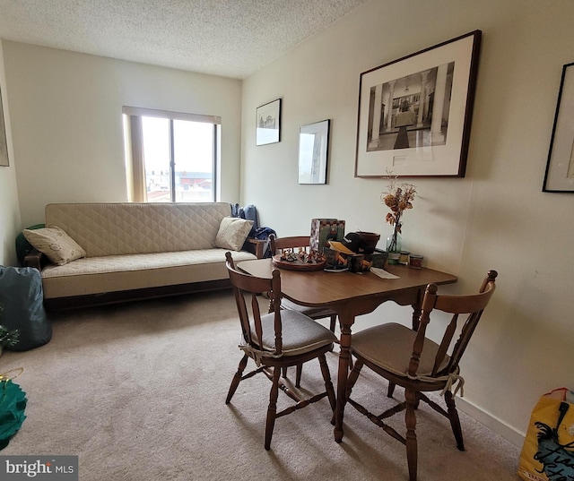 carpeted dining area featuring a textured ceiling